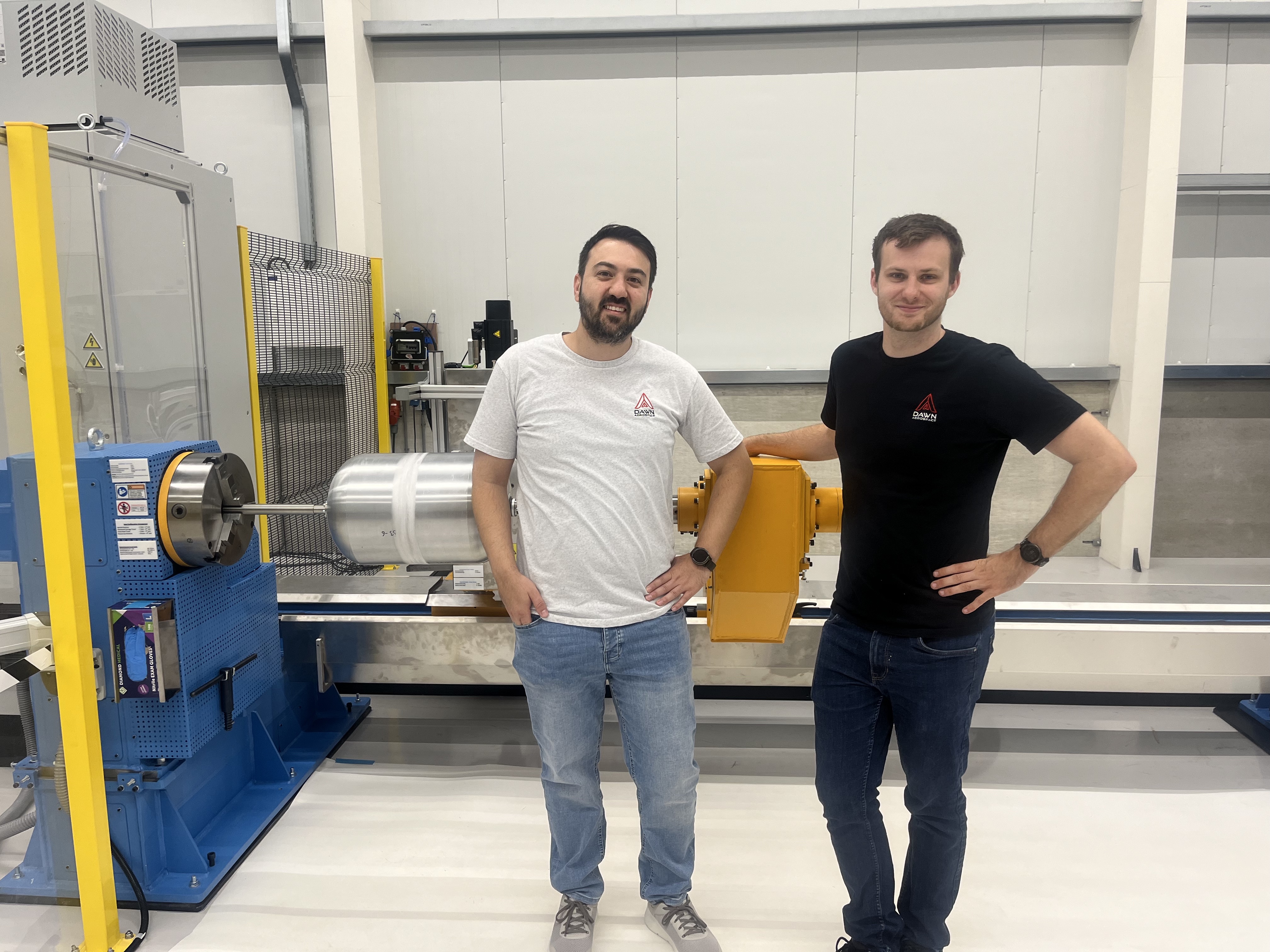 Dawn Aerospace team members stand in front of Composite Overwrapped Pressure Vessel propellant tank 